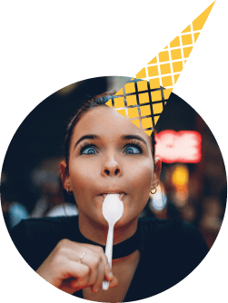 A woman with a spoon and a yellow ice cream cone hat at Modelland